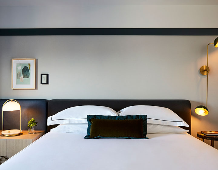 Guest bed with side tables and lamps at Kimpton Saint George Hotel